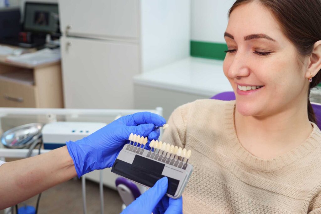 02 A dentist displays ceramic tooth color samples for a young patient to choose from.