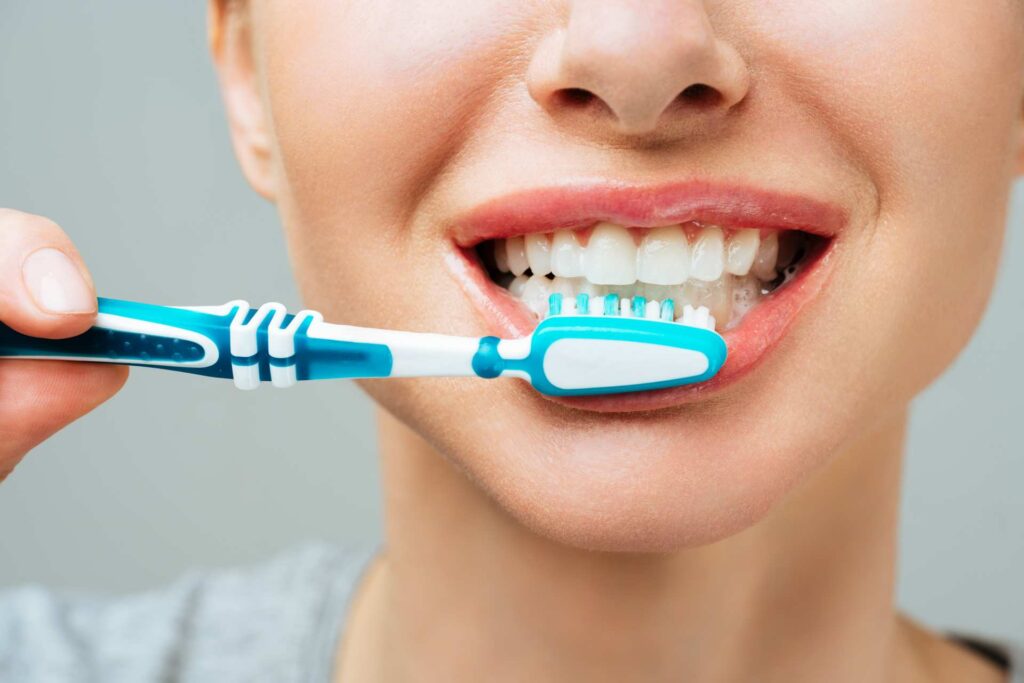 09 A girl smiling while brushing her teeth