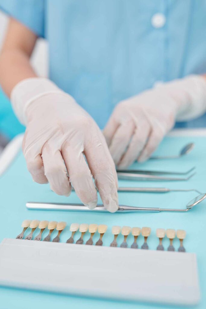 05 A technician with dental instruments and a porcelain veneer color chart.