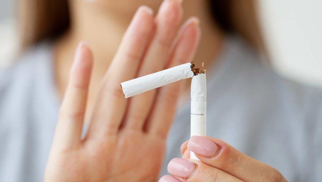 05 Detail of a young woman's hands holding a split cigarette indicating rejection of smoking.