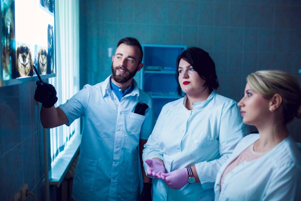 05 Dental team examining a patient's x-ray film_Dental implants procedure, dental implants in Miami