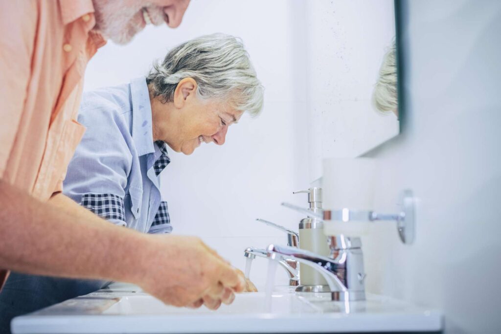 06 Elderly couple performing personal hygiene tasks together in a double sink_Dental implants pros and cons, dental implants in Miami