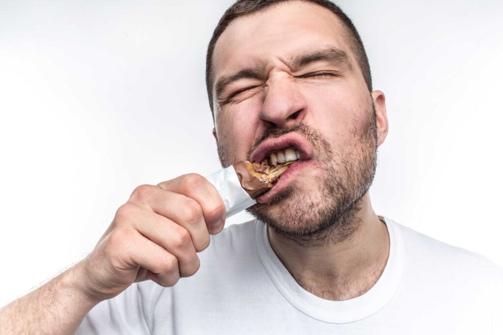 09 Man eating a Snickers-type nougat chocolate bar