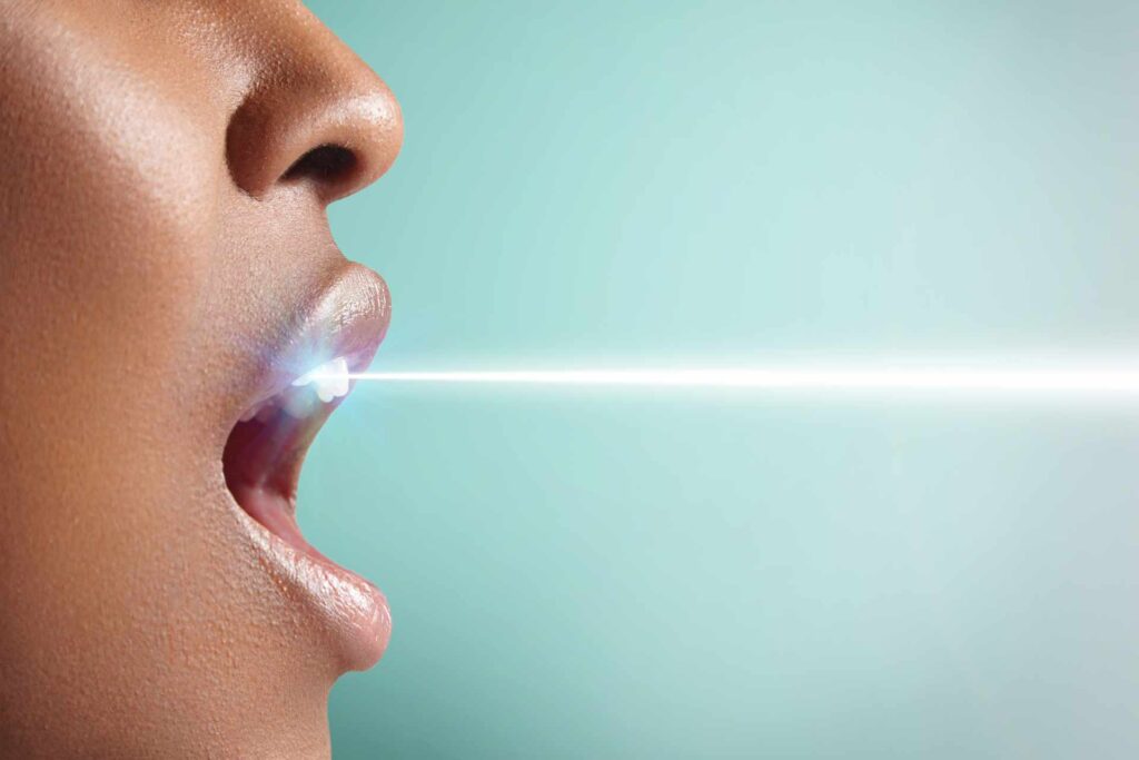 Visual recreation of a coherent laser beam reaching a woman's teeth